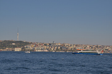 Fototapeta na wymiar ferryboats on Bosporus strait and Anatolian side of Istanbul city view from Dolmabahce Palace pier