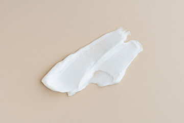 Smears of white cream on a beige background, cream texture