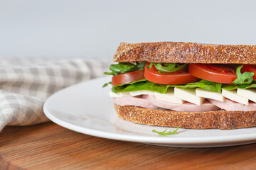 Sandwich with meat and cheese on a white plate