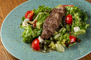Salad with asparagus, tomatoes, greens, tofu cheese, sesame and baked meat