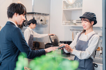 カフェでクレジット決済をするビジネスマン