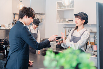 カフェでクレジット決済をするビジネスマン