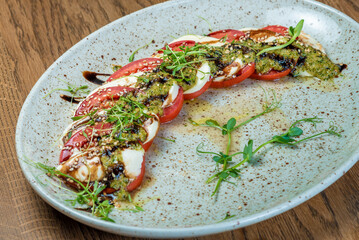 chopped tomatoes with sauce and greens on a plate