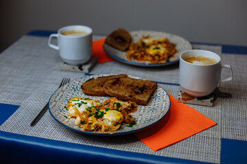 Breakfast, scrambled eggs with toast and coffee in a white cup