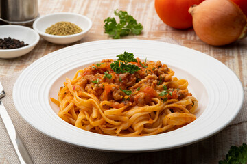 Spaghetti with minced pork in tomato sauce, pasta with a meat based bolognese tomatoes,served on white plate, linguine pasta