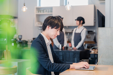 Fototapeta premium カフェでパソコンを使うビジネスマン