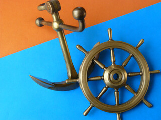 Nautical theme with a helm and an anchor on a colored background.