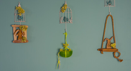 Fototapeta na wymiar Easter decorations on the wall, a cage with a bird, a nest with an egg and a bunny