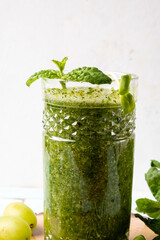 A glass of microgreens and mint smoothie, a healthy green drink.