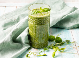 Smoothie green with microgreens, wheat sprouts and grapes. Wooden background.