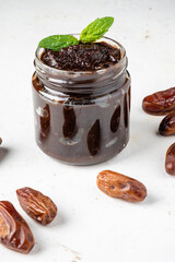 Useful date paste in a glass jar, light background.