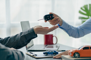 The dealer or dealership gives the car keys to the new owner. Customer signs insurance document or...