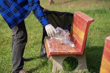 Close up of hands with plastic bottles with volunteer young man collecting plastic bottles in...