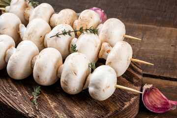 Champignons before barbecue on skewers. Close-up.