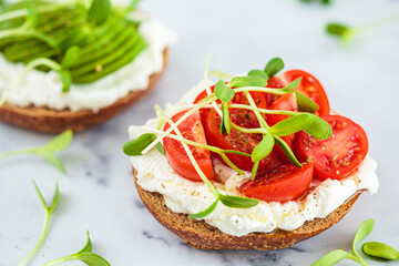 Toast with cream cheese, cherry tomatoes and micro greens. Healthy breakfast concept.