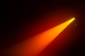 Orange blurred beam of stage light on a dark background.