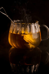 Hot tea on black background and reflection