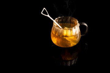 Hot tea on black background and reflection
