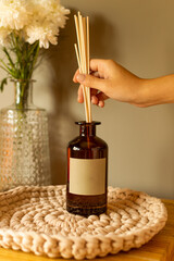 Naklejka premium Hand placing toothpick into aroma diffuser