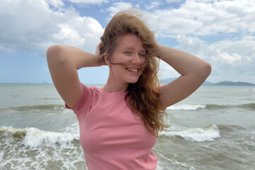 Portrait of beautiful relaxed happy positive girl, young carefree woman is enjoying sea summer vacation, smiling, looking at camera