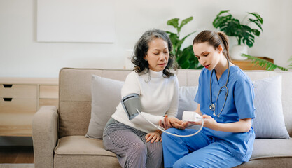 Medical doctor holing senior patient's hands and comforting her at home