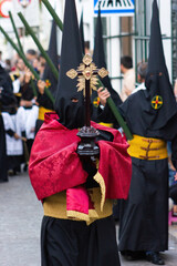 Penitent or Nazarene carrying a cross during the Holy Week procession.