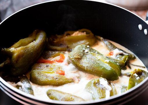 Traditional homemade bell pepper stuffed with cheese and cream sauce in a cooking pot, latin food