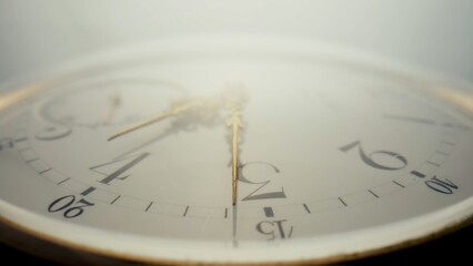 Antique pocket watch with a white dial and gold hands in bright light. The face of an old clock...