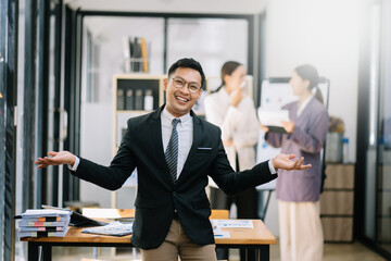 Young attractive Asian male office worker business suits smiling at camera in office