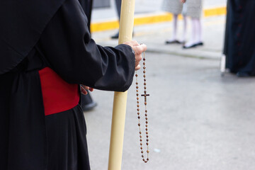 Nazarene or penitent carrying a rosary in the Holy Week procession.