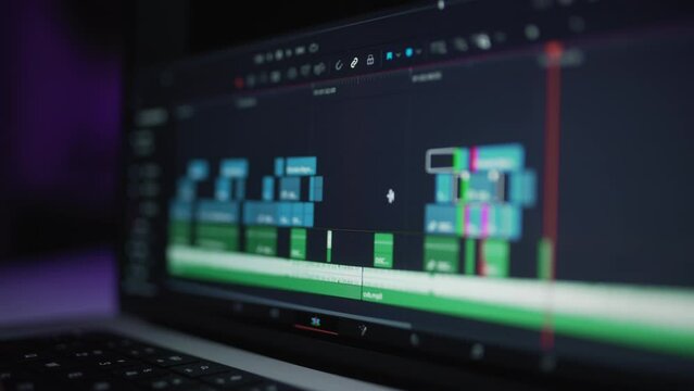 A human editor uses a laptop to creatively create a video clip. Makes color correction of video content. A freelance colorist works at home in the studio. The cinematographer is editing the film