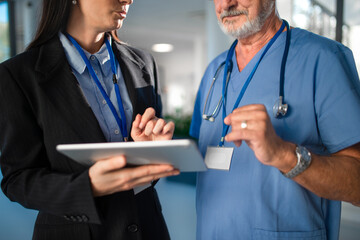 Fototapeta premium Young business woman shaking hand with elderly doctor.