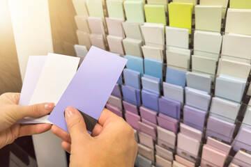 Choose a paint color from the swatches.The designer selects an interior design color from a palette...