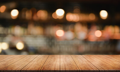 Empty wooden table top with lights bokeh on blur restaurant background.	