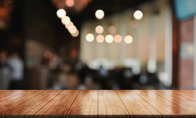 Empty wooden table top with lights bokeh on blur restaurant background.	