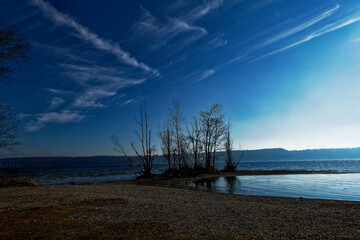 lake with reflecting water surface and clouds located at bavaria &ndash; germany, landscape at winter time