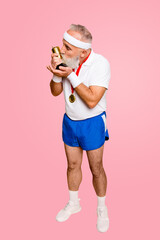 Full length side profile of crazy comic emotional cool grandpa holding precious reward. Body, health, care, lifestyle, game, challenge, champ, hero, leisure, training, workout, strength, power