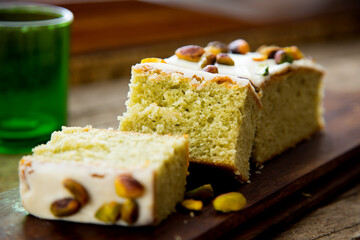 Pistachio sponge cake covered in icing sugar.