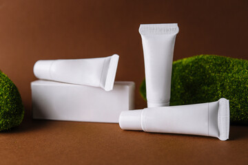 Moisturizer cream white tubes among natural green moss