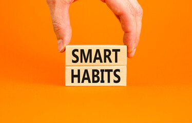 Smart habits symbol. Concept words Smart habits on wooden blocks. Beautiful orange table orange background. Businessman hand. Business and smart habits concept. Copy space.