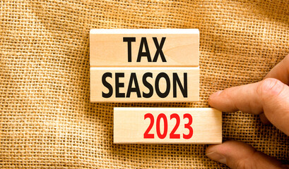 Tax season 2023 symbol. Concept words Tax season 2023 on wooden blocks on a beautiful canvas table canvas background. Businessman hand. Business Tax season 2023 concept. Copy space.