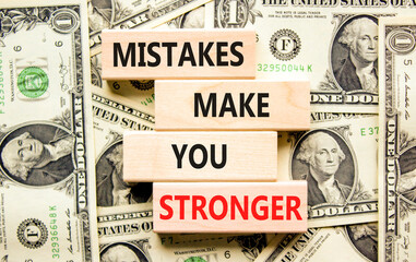 Naklejka na ściany i meble Mistake make stronger symbol. Concept words Mistakes make you stronger on wooden blocks. Dollar bills. Beautiful background from dollar bills. Business mistake make stronger concept. Copy space.