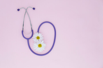 Obraz na płótnie Canvas Stethoscope, white flower on pink background with copy space. Medical flat lay. International Nurse's Day. Women's Day. March 8th