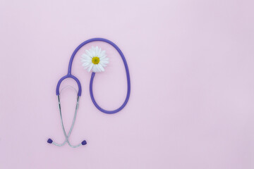 Stethoscope, white flower on pink background with copy space. Medical flat lay. International...
