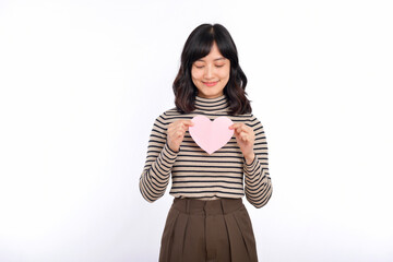 Beautiful young asian woman holding a paper heart while standing against white background. Beautiful young asian woman with paper heart.