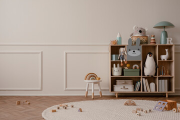 Interior design of kid room interior with copy space, wooden sideboard, round rug, beige wall with stucco, plush toys, white stool, wooden blockers and personal accessories. Home decor. Template.
