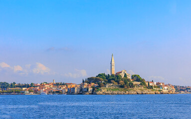 Fototapeta premium The old town of Rovinj with the church of St. Euphemia seen from the sea on a sunny day with blue sky