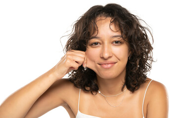 Portrait of young etnic woman, pulling her cheek skin on white background