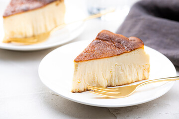 明るいテーブルにバスクチーズケーキと金色のフォーク