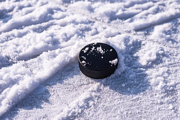 hockey puck lies on the snow close-up